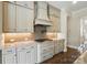 Custom range hood stands above the backsplash and stove at 300 Wheatberry Hill Dr, Weddington, NC 28104