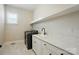 Bright laundry room with modern appliances, sleek countertops, and ample storage at 300 Wheatberry Hill Dr, Weddington, NC 28104