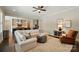 Open-concept living room with a view of the kitchen, showcasing modern decor, comfortable seating, and hardwood floors at 300 Wheatberry Hill Dr, Weddington, NC 28104