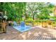 Spacious wooden deck area with a seating area surrounded by trees and lush greenery in the backyard at 3043 Charles Rd, Shelby, NC 28152