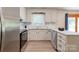 Open kitchen layout featuring stainless steel refrigerator, stove, updated white cabinets, and tile backsplash at 3043 Charles Rd, Shelby, NC 28152