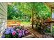 Beautifully landscaped yard featuring vibrant hydrangeas, lush greenery, and a charming wooden foot bridge at 3043 Charles Rd, Shelby, NC 28152