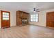 Cozy living room featuring a brick fireplace, hardwood floors, and windows providing ample natural light at 3043 Charles Rd, Shelby, NC 28152