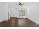 Bright living room featuring hardwood floors, a ceiling fan, and a large window for natural light at 3153 Bending Birch Pl, Charlotte, NC 28206
