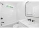 Modern bathroom features white tile, black fixtures, and vanity with a sleek mirror at 338 Hollingswood Dr, Statesville, NC 28625