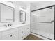 Bright bathroom featuring double sinks, white cabinets, and a glass shower at 338 Hollingswood Dr, Statesville, NC 28625