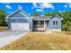 Charming home featuring an attached garage, light blue siding, and a well-manicured front lawn at 338 Hollingswood Dr, Statesville, NC 28625