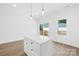 Bright kitchen featuring an island, white cabinets, and hardwood floors at 338 Hollingswood Dr, Statesville, NC 28625