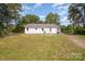 Exterior view of the home surrounded by a lush green lawn with mature trees on a sunny day at 3595 Mt Holly Rd, Edgemoor, SC 29712
