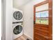 A laundry room featuring a stacked washer and dryer next to an entry door at 3595 Mt Holly Rd, Edgemoor, SC 29712