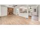 Open-concept living space featuring a brick fireplace, ceiling fan, and view into the updated kitchen at 3595 Mt Holly Rd, Edgemoor, SC 29712