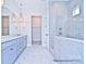 Modern bathroom featuring double vanity, pendant lights, and a tiled bathtub and shower at 4178 Millstream Rd, Denver, NC 28037