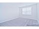 This bedroom features a plush carpet, a window letting in plenty of light, and neutral walls at 4178 Millstream Rd, Denver, NC 28037