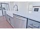 Kitchen island featuring a farm sink, modern faucet, and stainless steel dishwasher at 4178 Millstream Rd, Denver, NC 28037