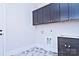 This laundry room features dark cabinets, granite counter tops, and fun geometric tile at 4178 Millstream Rd, Denver, NC 28037