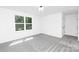 Bright bedroom with gray carpet, closet doors, and a window at 428 Clay St, Mooresville, NC 28115