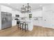 White kitchen with stainless steel appliances, a center island, and modern black pendant lighting at 428 Clay St, Mooresville, NC 28115