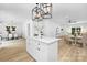 Open concept kitchen features an island with modern lighting and a view into the living and dining areas at 428 Clay St, Mooresville, NC 28115