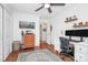 Bright bedroom featuring a ceiling fan, hardwood floors, a computer desk, and floating plant shelves at 433 W 8Th St # 66, Charlotte, NC 28202