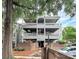 Multi-level condo building with balconies, brick accents, mature trees, and parking at 433 W 8Th Street St, Charlotte, NC 28202