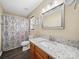 Bathroom featuring granite counters, wood cabinets, patterned shower curtain, and modern fixtures at 471 Hillandale Ne St, Concord, NC 28025