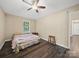Bedroom with ceiling fan, window view, neutral paint, and wood-look flooring at 471 Hillandale Ne St, Concord, NC 28025