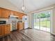 Kitchen area with wood cabinets, granite counters, white fridge, and sliding doors to backyard at 471 Hillandale Ne St, Concord, NC 28025