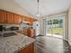 Kitchen area features wood cabinets, granite counters, white fridge, and backyard access at 471 Hillandale Ne St, Concord, NC 28025