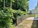 A rustic wooden fence runs along the edge of a well-maintained backyard, bordering dense, lush greenery at 5800 Silver Eagle Dr, Charlotte, NC 28214