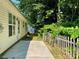 Side view of a home featuring a concrete patio and a wooden fence partially obscured by lush greenery at 5800 Silver Eagle Dr, Charlotte, NC 28214