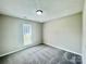 Bedroom featuring neutral carpet and trim with a single window for natural light at 5800 Silver Eagle Dr, Charlotte, NC 28214