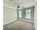 Spacious bedroom with neutral carpet, trim, and ceiling fan, filled with natural light from two windows at 5800 Silver Eagle Dr, Charlotte, NC 28214