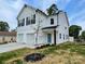 New construction home with white siding, blue door and a two car garage at 619 Billingsley Rd, Charlotte, NC 28211