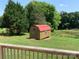View of a barn shed with a red roof, complemented by the natural beauty of surrounding trees at 6219 Heavner Rd, Vale, NC 28168