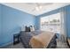 Well-lit bedroom with ceiling fan, large window, and blue accent wall at 635 Brickdust Ct, Fort Mill, SC 29708