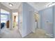 Upstairs hallway with neutral carpet, access to rooms, and laundry closet at 635 Brickdust Ct, Fort Mill, SC 29708