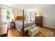 Comfortable bedroom with hardwood floors, four-poster bed, and matching wood furniture at 6434 Sardis Rd, Charlotte, NC 28270