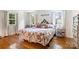 Bright bedroom featuring hardwood floors, floral bedding, and natural light from two windows at 6434 Sardis Rd, Charlotte, NC 28270