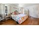 Bright bedroom featuring hardwood floors, floral bedding, and ample natural light from the nearby windows at 6434 Sardis Rd, Charlotte, NC 28270