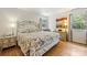 Bright bedroom showcasing hardwood floors, floral bedding, and dresser with painting at 6434 Sardis Rd, Charlotte, NC 28270
