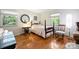 Well-lit bedroom with hardwood floors, round mirror, and charming furniture at 6434 Sardis Rd, Charlotte, NC 28270