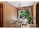 Bright dining room features a glass table set and a view of the outdoor space through sliding glass doors at 6434 Sardis Rd, Charlotte, NC 28270
