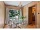 Sunny dining area with a glass table set and view of the outdoor space through sliding glass doors at 6434 Sardis Rd, Charlotte, NC 28270