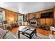 Bright living room featuring wood paneling, a brick fireplace, and hardwood floors bathed in natural light at 6434 Sardis Rd, Charlotte, NC 28270