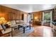 Cozy living room featuring wood paneling, hardwood floors, and a window nook that streams natural light at 6434 Sardis Rd, Charlotte, NC 28270