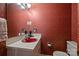 Small powder room featuring red floral wallpaper and a contrasting red sink at 6434 Sardis Rd, Charlotte, NC 28270