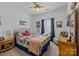 Cozy bedroom featuring a ceiling fan, warm decor, and natural light from the window with blue curtains at 6438 Hove Rd, Mint Hill, NC 28227