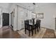 Formal dining room with a black wood table and chairs, bright windows, and hardwood floors at 6438 Hove Rd, Mint Hill, NC 28227