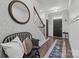 Inviting entryway featuring a decorative mirror, staircase, stylish bench, and a patterned rug leading to the front door at 6438 Hove Rd, Mint Hill, NC 28227