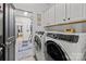 Well-equipped laundry room features white cabinets, a front-loading washer and dryer at 6438 Hove Rd, Mint Hill, NC 28227